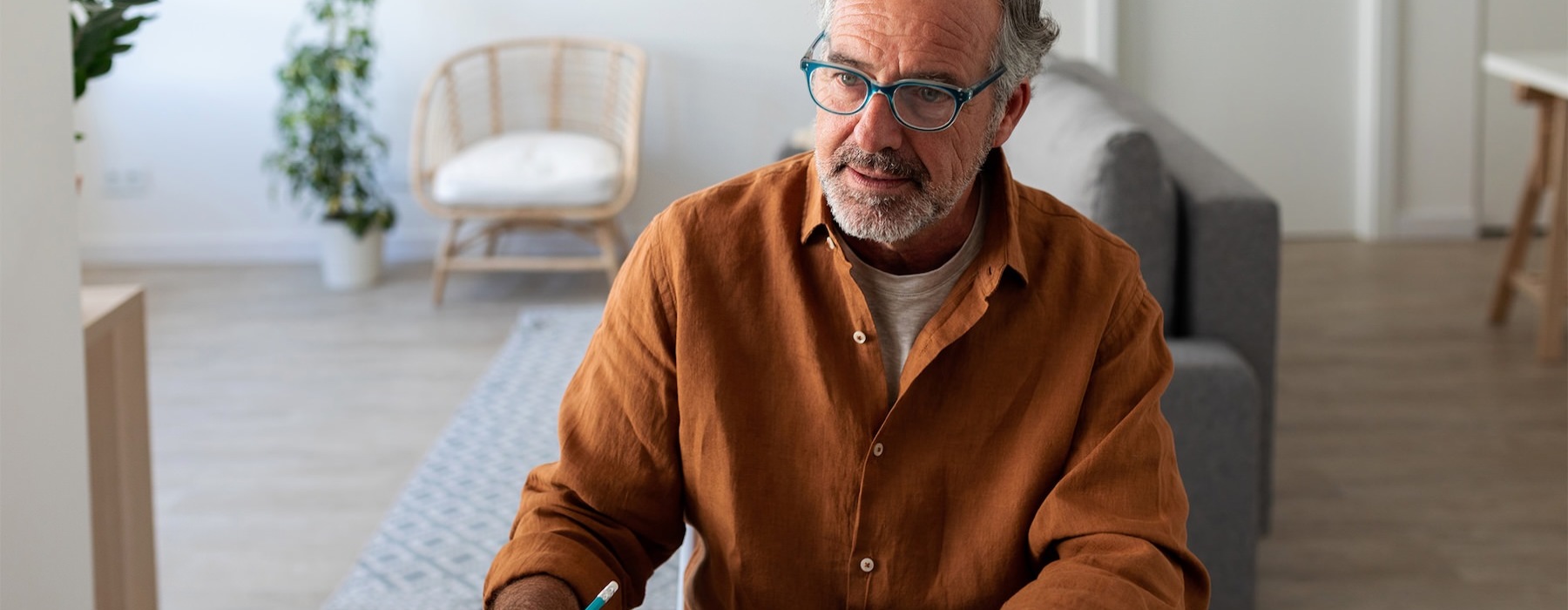 a man sitting at a table writing on a piece of paper